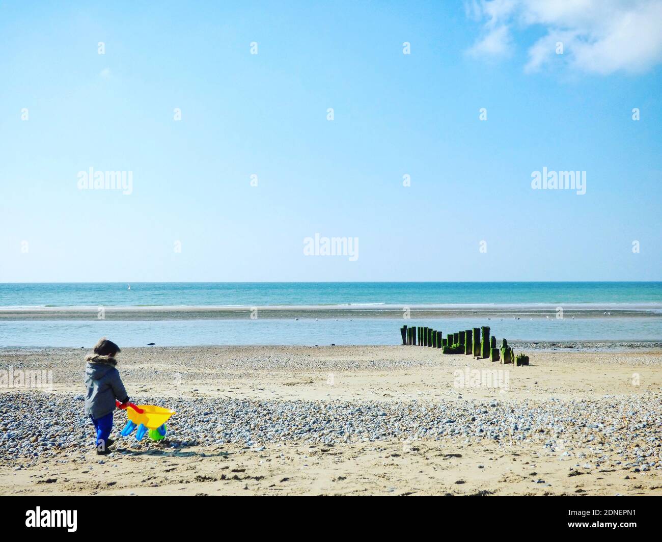 Junge Mit Radkarren Am Strand Stockfoto