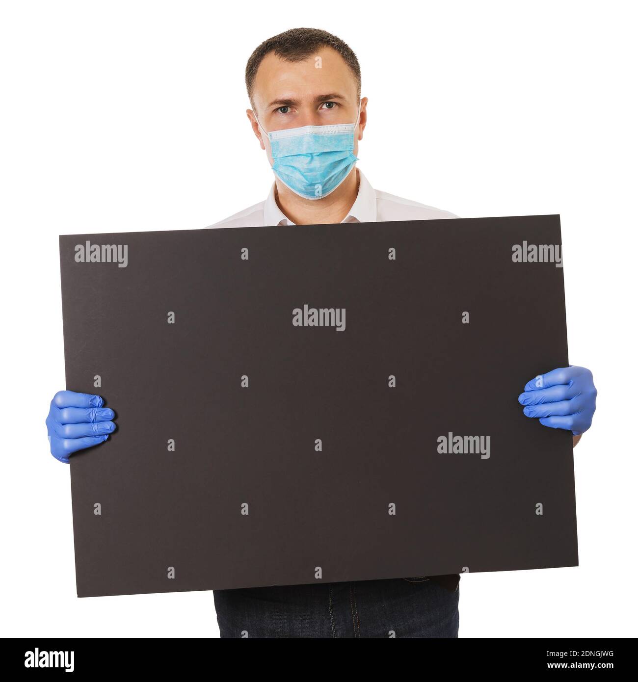 Ein Mann in einer medizinischen Maske und Handschuhen hält ein leeres schwarzes Blatt Pappe für Ankündigungen, isoliert auf einem weißen Hintergrund. Layout für Text. Stockfoto