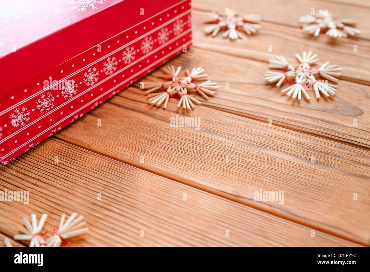 Neujahrskarte mit Platz für Text. Rote Box, Stroh Schneeflocken. Stockfoto