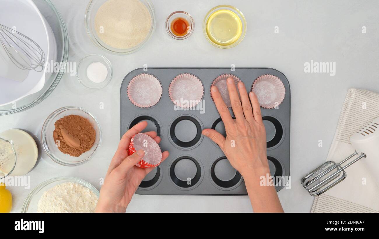 Schokolade Muffins oder Schokolade Cupcakes Rezept. Eine Muffin-Pfanne mit Papier Cupcakes Liner auslegen, Nahaufnahme von oben Stockfoto
