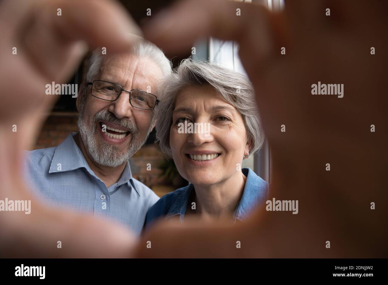 Glücklich Bonding ältere Familie Paar macht Herz Zeichen mit Fingern. Stockfoto