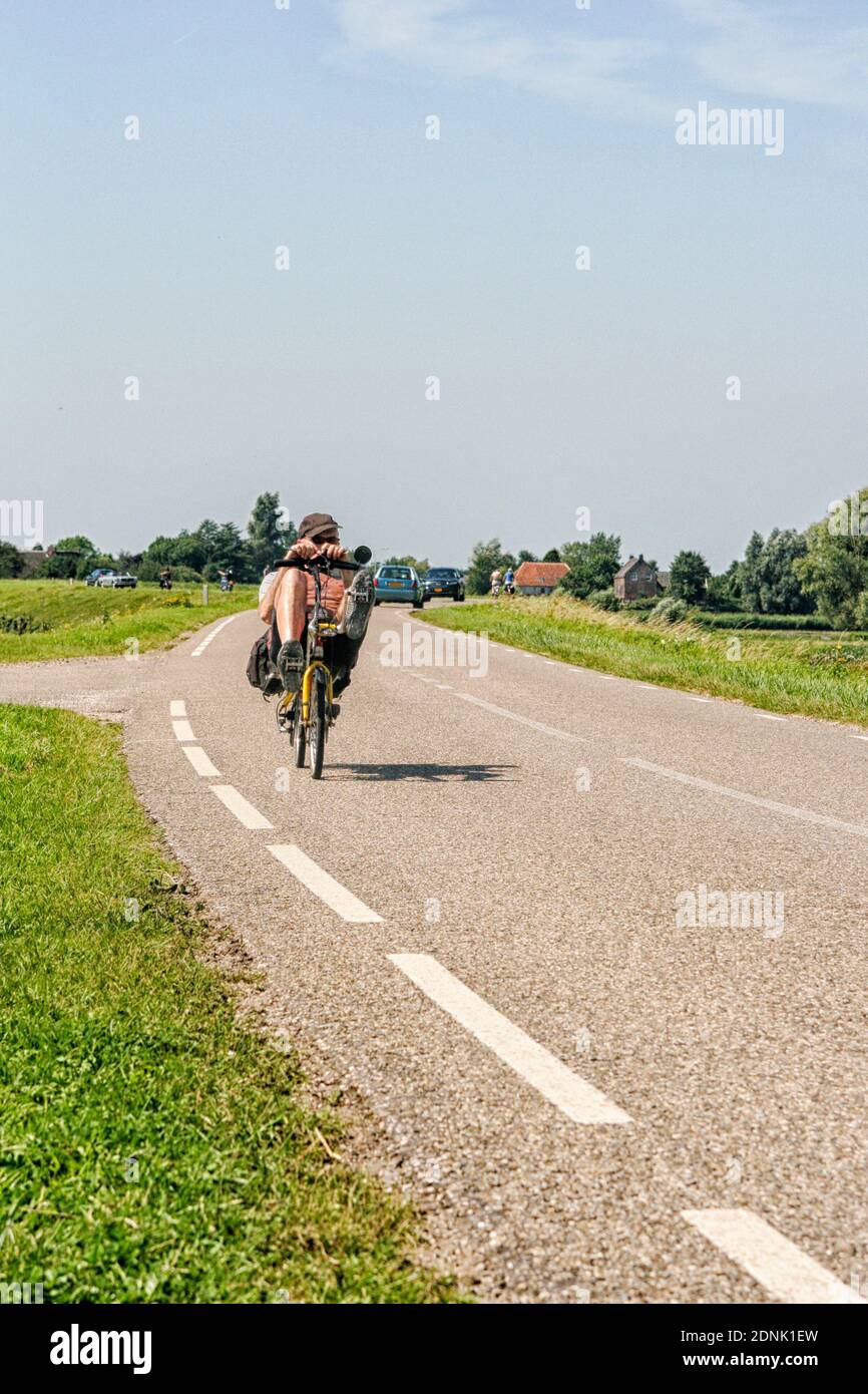 Mann auf rekumbant Fahrrad auf Deich in den Niederlanden Stockfoto