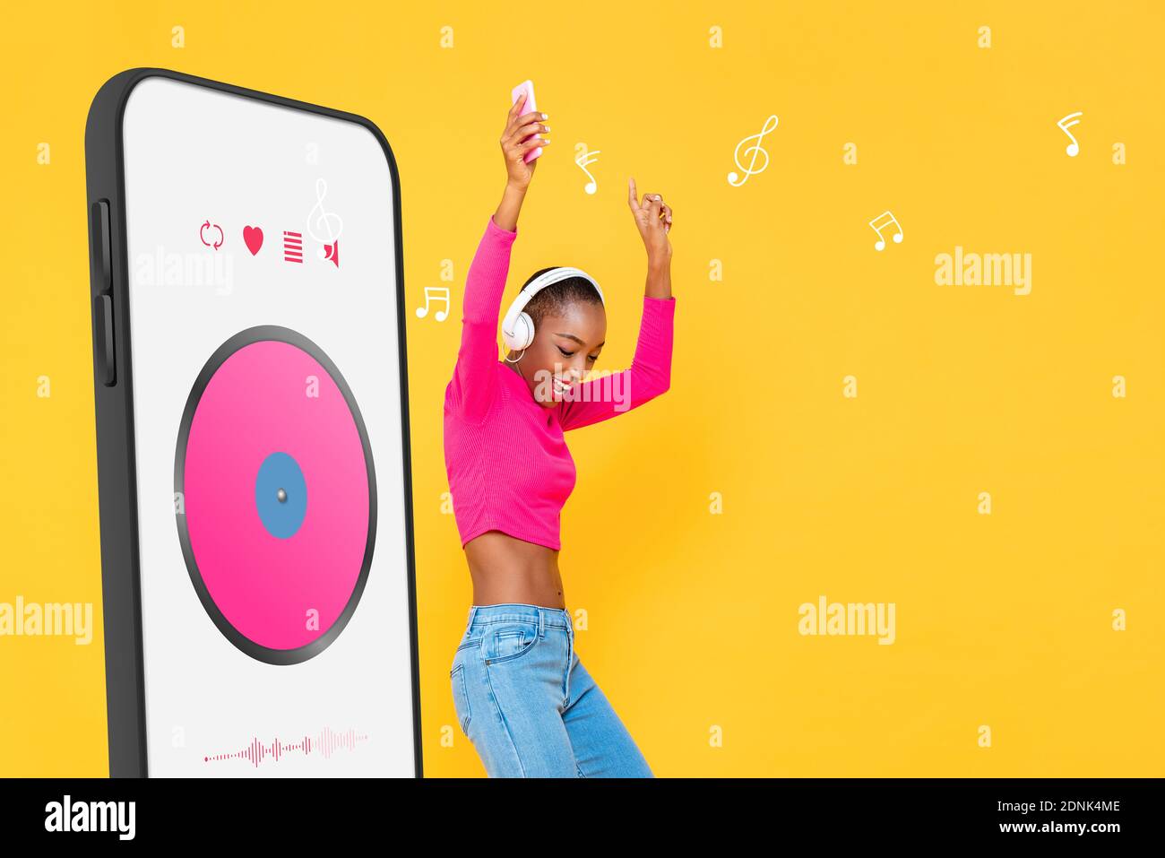 Glückliche afroamerikanische Frau, die Kopfhörer trägt und Musik streamt Von Smartphone-Anwendung und Tanz auf bunt gelb isoliert studi Stockfoto