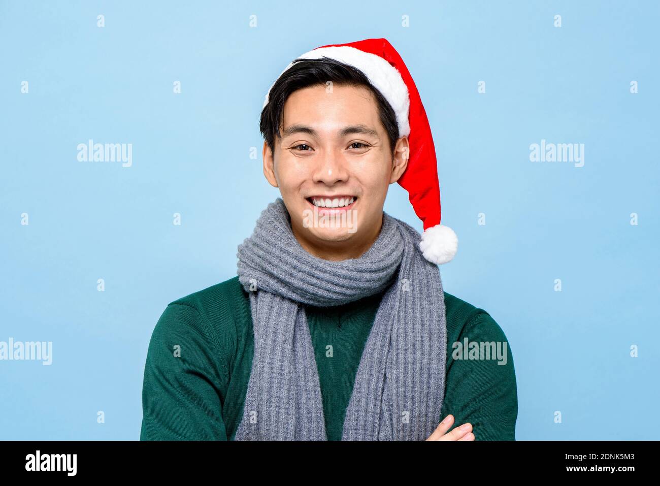 Nahaufnahme Porträt des glücklichen asiatischen Mann in Weihnachtskleidung Lächelnd auf hellblauem isoliertem Hintergrund Stockfoto