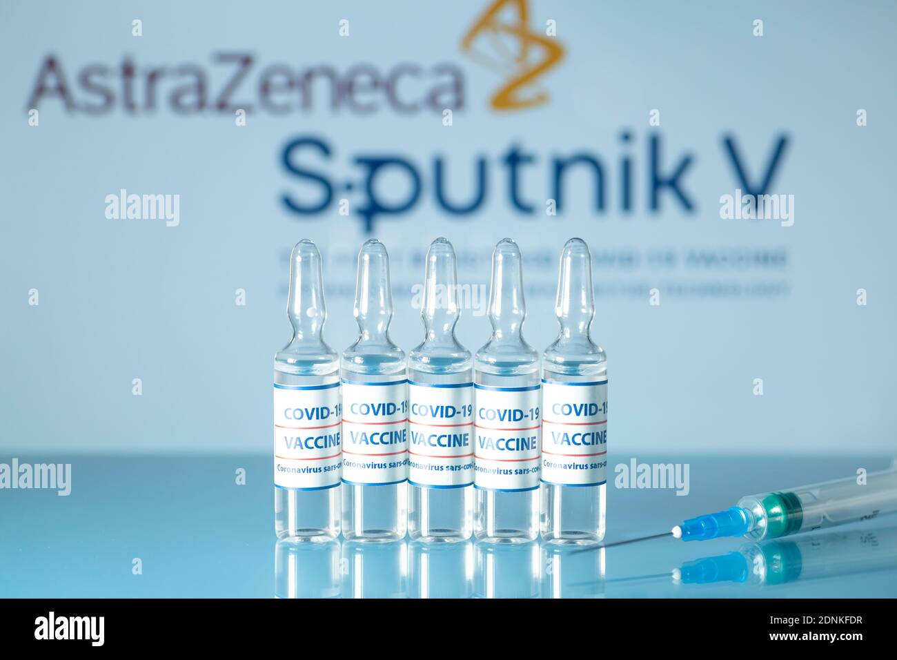 Sputnik 5 und AstraZeneca gegen COVID-19. Medizinische Glasfläschchen mit Flüssigkeit auf dem Hintergrund. Sputnik V und AstraZeneca Logo. Ampullen mit Stockfoto