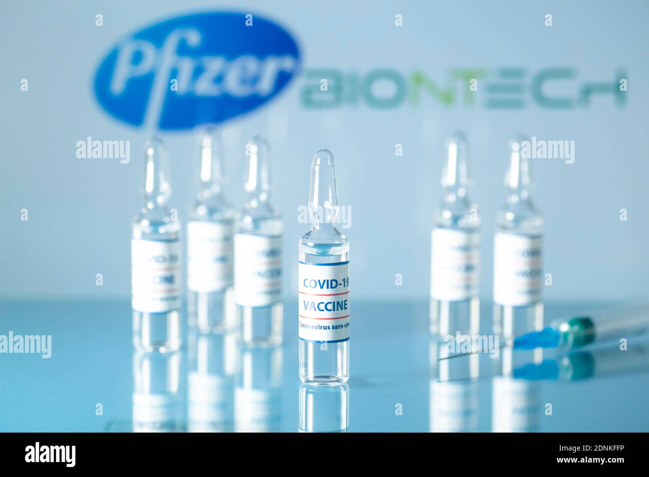 Pfizer- und BioNtech-Impfstoff gegen COVID-19. Medizinische Glasfläschchen mit Flüssigkeit auf dem Hintergrund Pfizer und BioNtech Logo. Ampullen mit Coronavirus va Stockfoto
