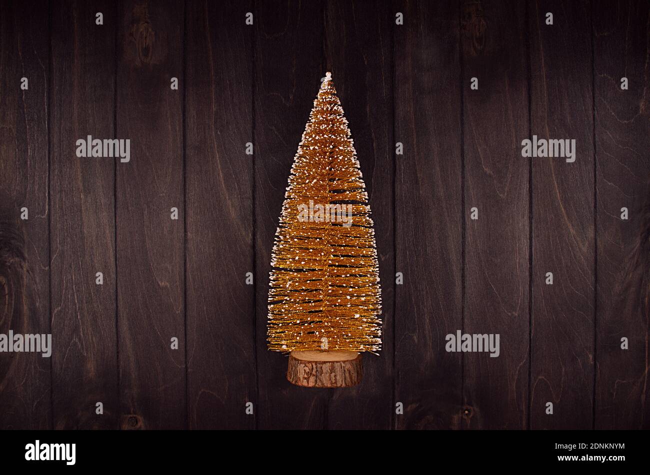 Goldener weihnachtsbaum mit Glitzer auf dunkelbrauner Planke, Draufsicht, Kopierraum. Stockfoto