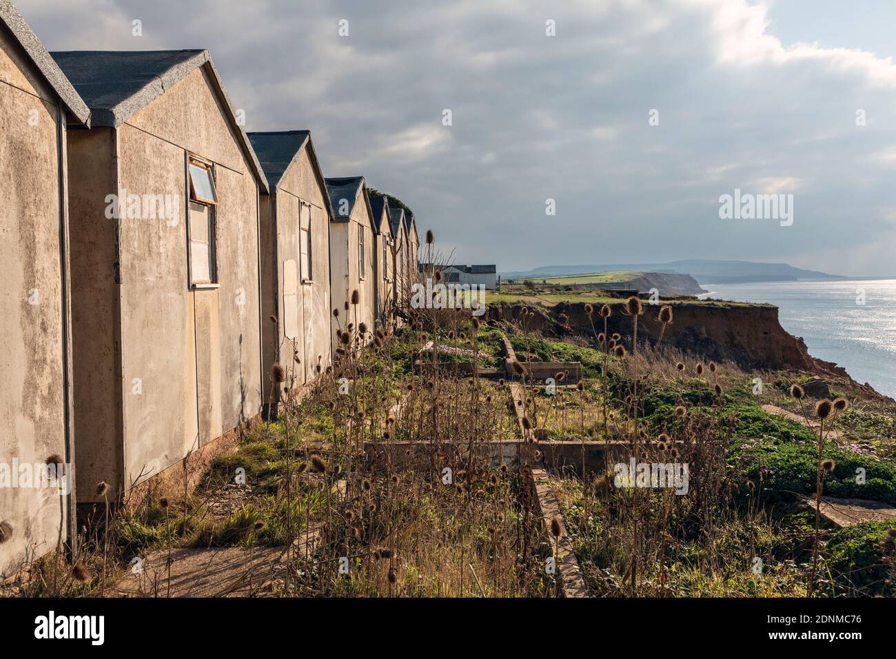 Verlassene Ferienchalets, die wegen der Abnutzung der Klippen in Brightstone Bay, Isle of Wight, aufgegeben wurden Stockfoto