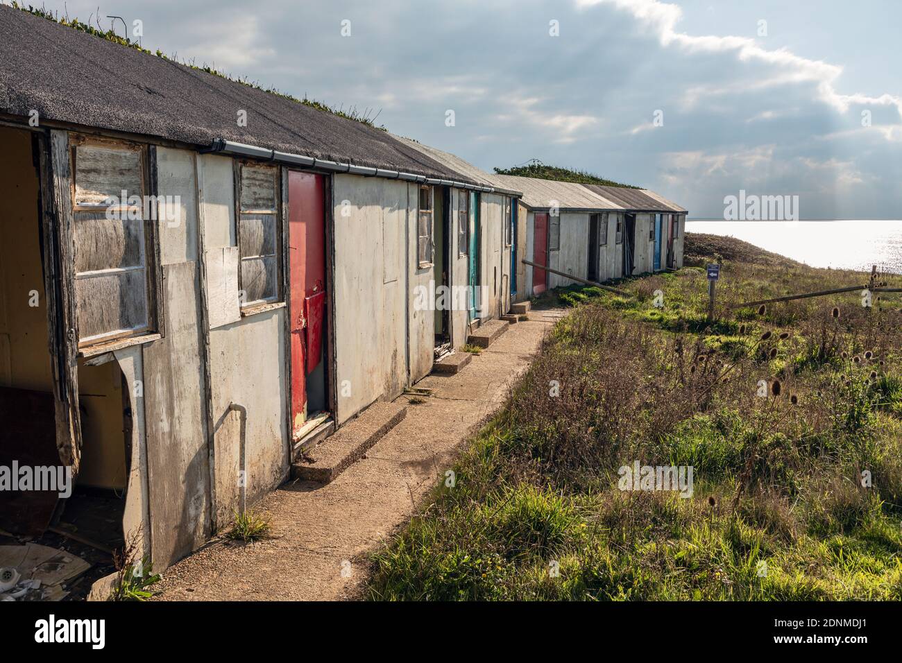 Verlassene Ferienchalets, die wegen der Abnutzung der Klippen in Brightstone Bay, Isle of Wight, aufgegeben wurden Stockfoto
