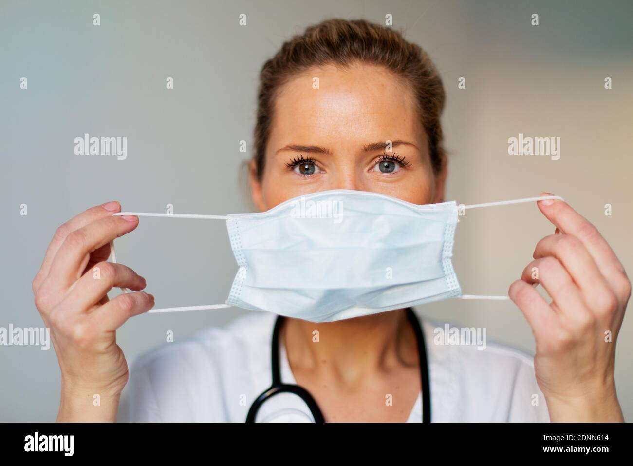 Ärztin, die Schutzmaske aufsetzt Stockfoto