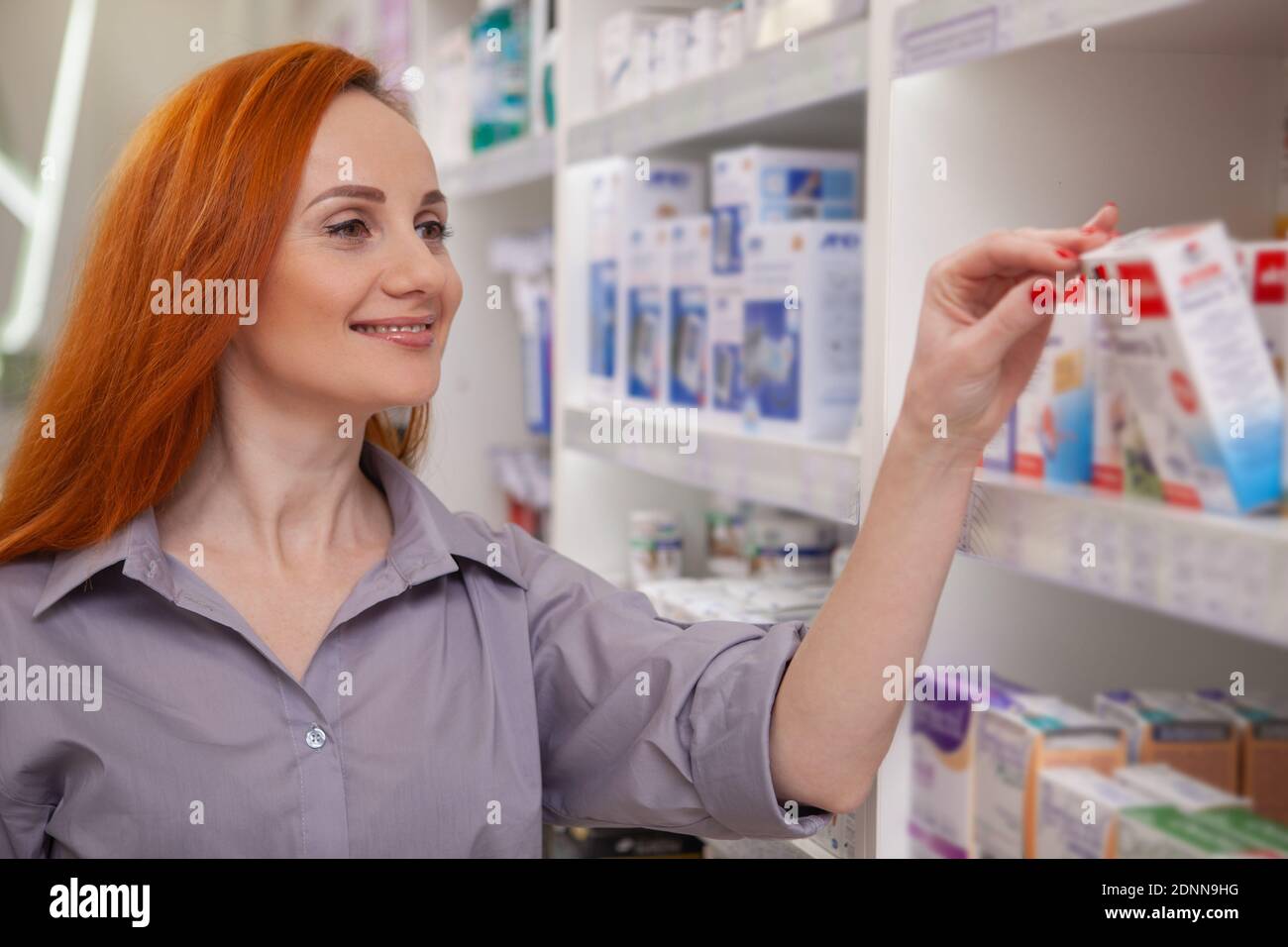 Glückliche gesunde Frau lächelnd, Kauf von Medikamenten in der Drogerie. Schöne fröhliche weibliche Kunden einkaufen in der Apotheke, Kopierer Platz. Kauf Stockfoto