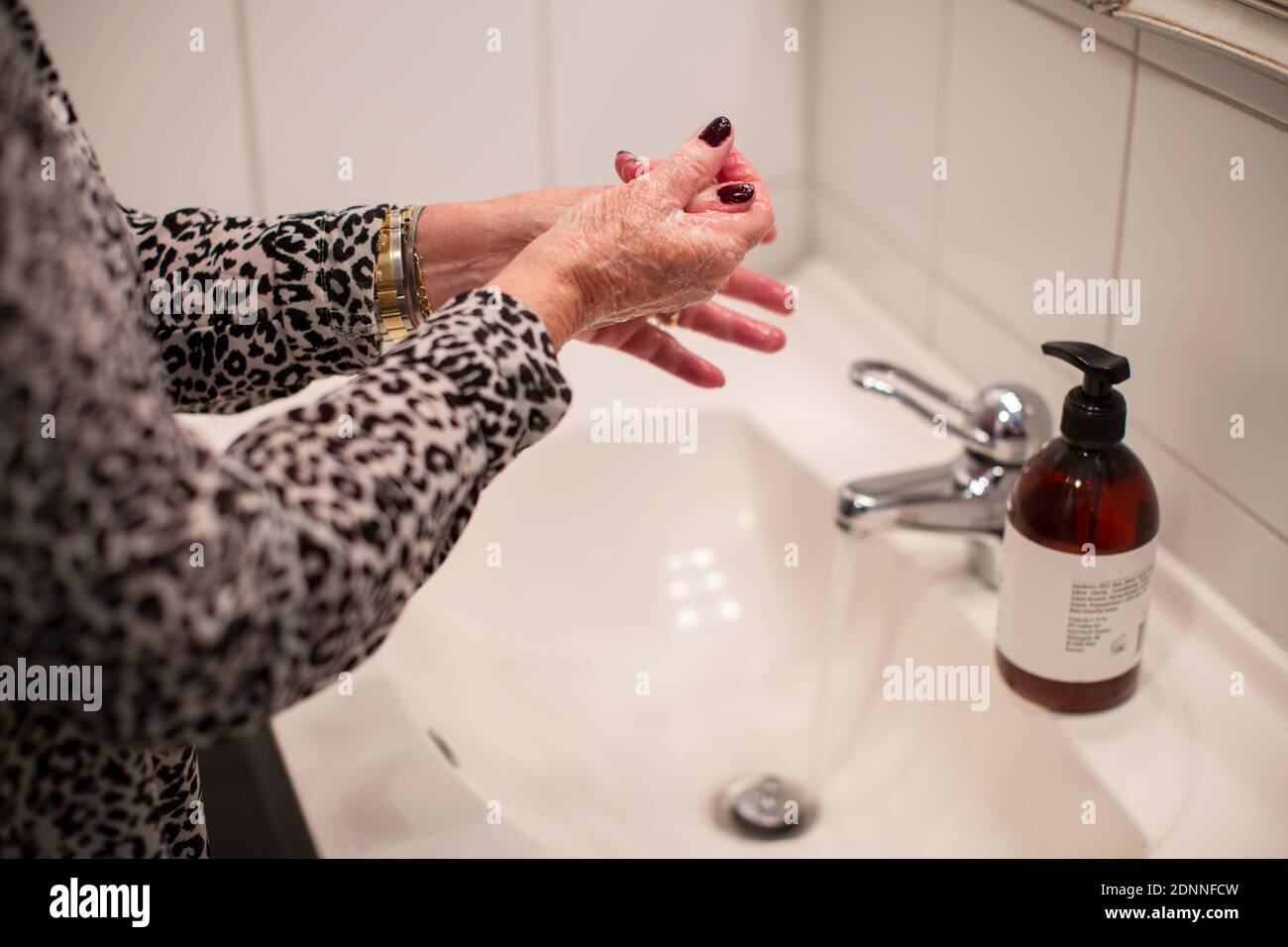 Frau Waschen der Hände mit Seife Stockfoto