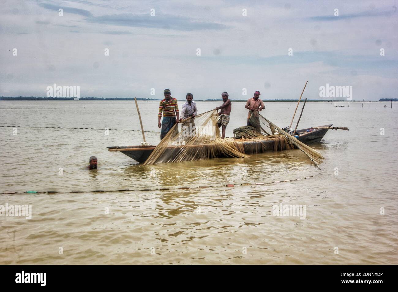 Unter Ausnutzung der Monsun-Saison, hat sich das Angeln in den Flüssen von Kurigram beliebt. Die Einheimischen sind auf der Jagd nach einheimischen Fischarten i beschäftigt Stockfoto