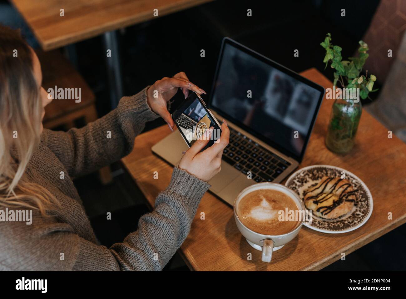 Woman taking photo in cafe Stockfoto