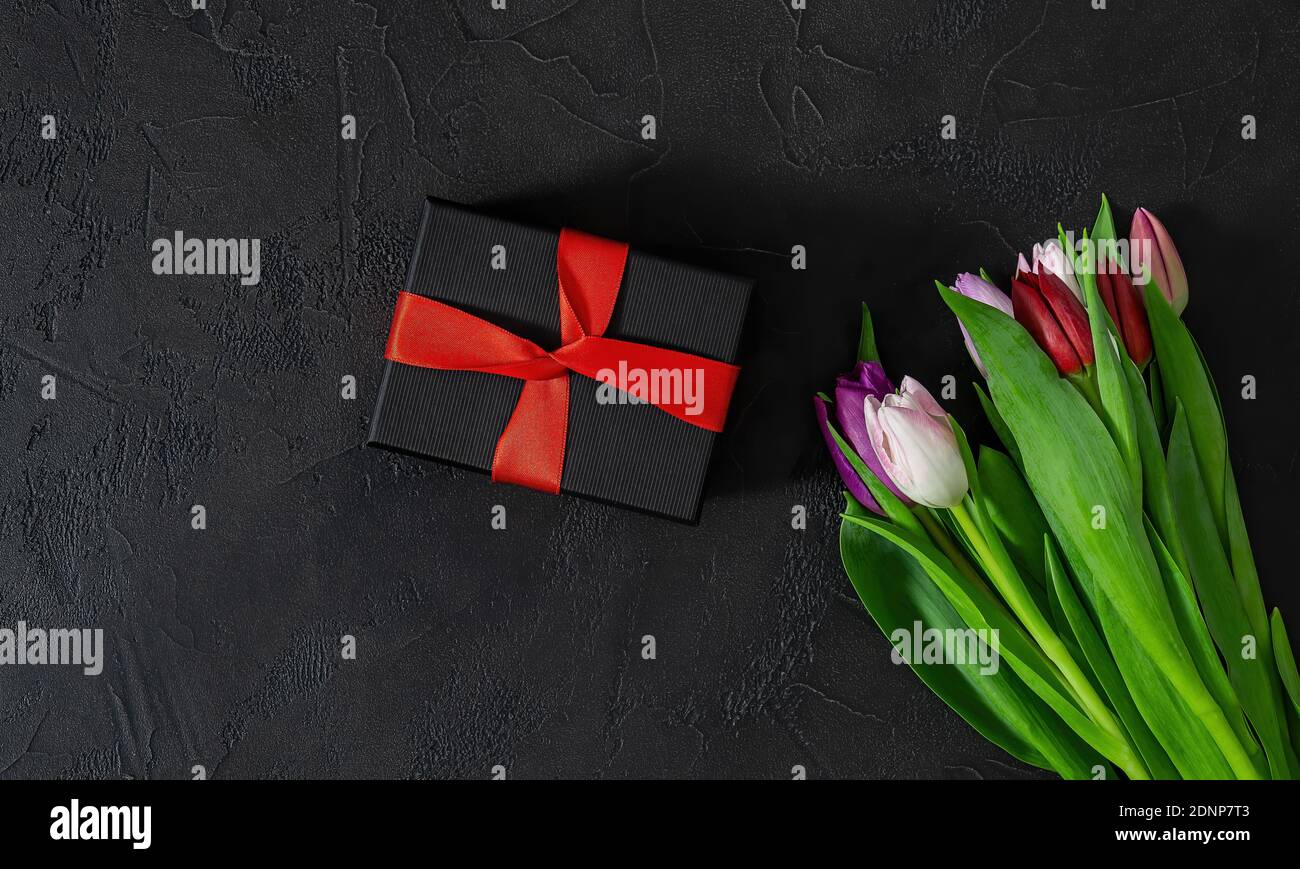 Happy Valentines Day, Frauentag, Muttertag Konzept. Geschenkbox und Tulpenblumen. Stockfoto