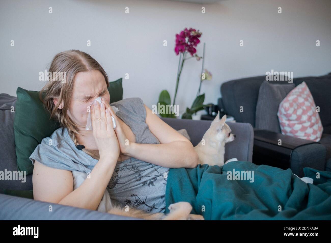 Frau auf dem Sofa niesen Stockfoto