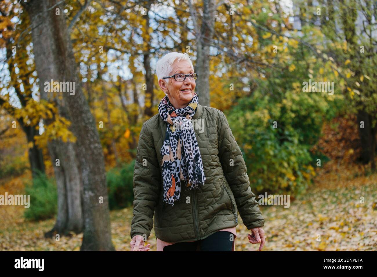 Ältere Frau, die im Herbst läuft Stockfoto