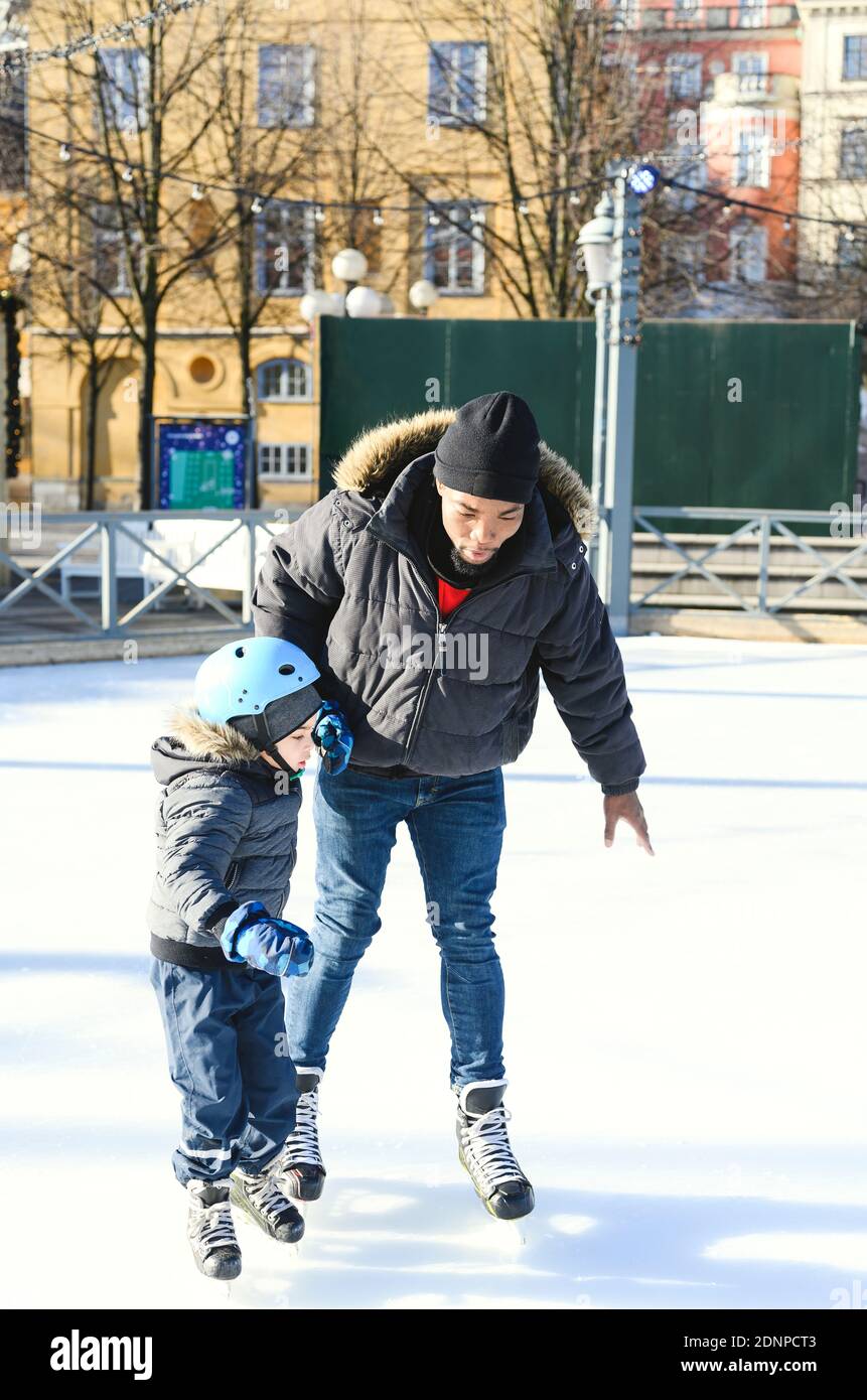 Vater unterrichtet Sohn Eislaufen Stockfoto