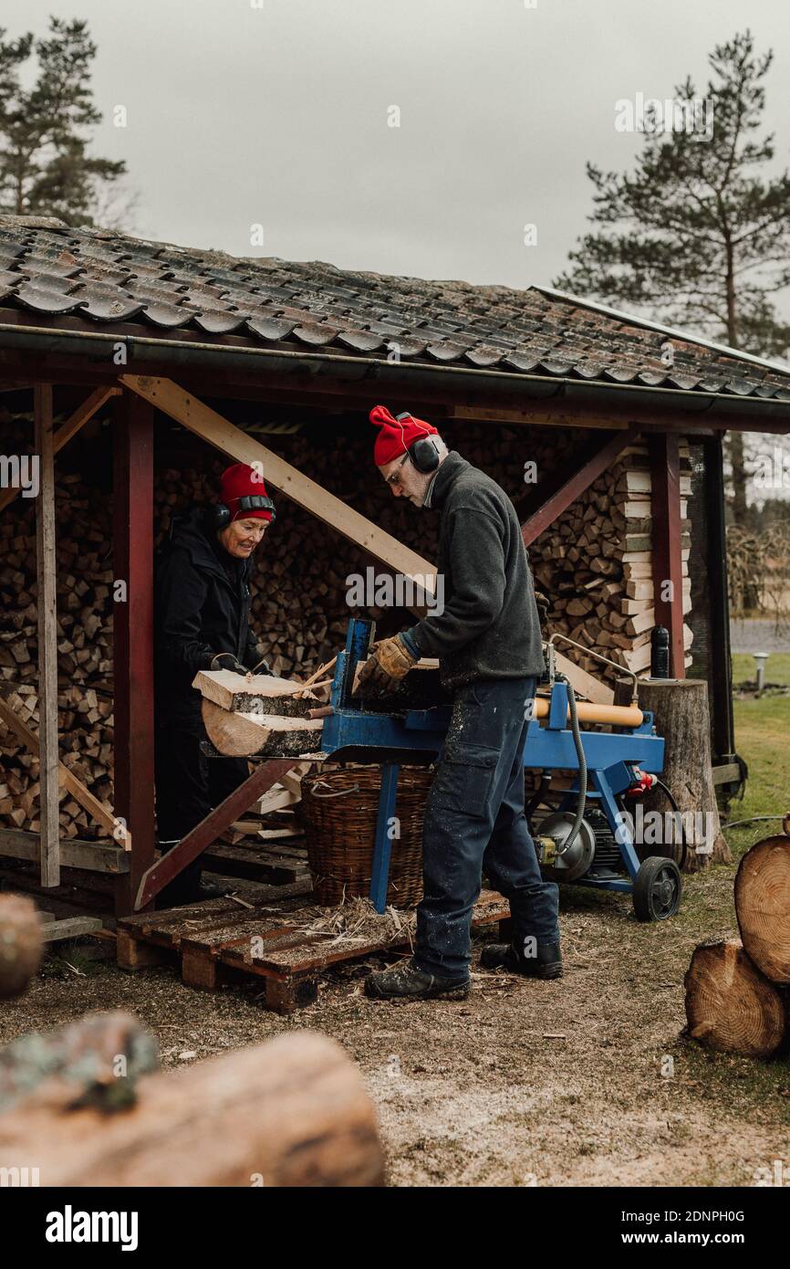 Seniorenpaar hackt Holz Stockfoto