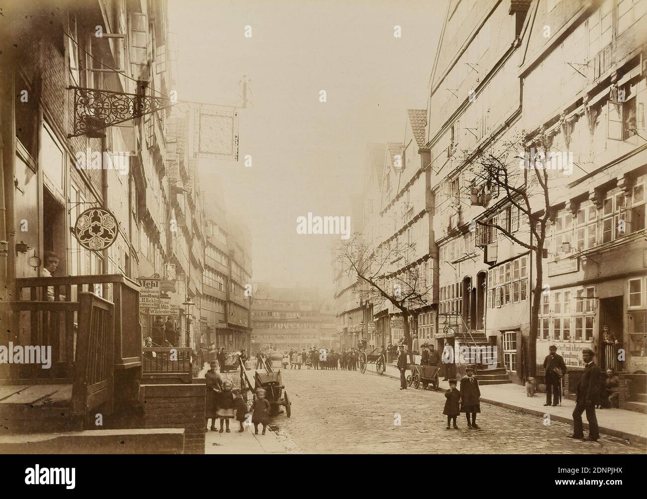 W. Mauke & Söhne, Georg Koppmann, Brook nach dem Sand aus der Mappe Hamburg 1883, zu legende Fotografien der Stadttheile, Albumin-Papier, schwarz-weiß-positiver Prozess, Bildgröße: Höhe: 27.3 cm; Breite: 38.5 cm, beschriftet: recto und bedruckt auf Trägerkarton: Photographie von G. Koppmann & Co, Hamburg - fotografiert Hamburg Oktober 1883, BACH NACH DEM SAND, Architekturfotografie, Stadt, Stadtansicht (veduta), Straßen und Plätze, Mehrfamilienhaus, Mehrgeschosshaus, Fassade, Haus, Gebäude, Fachwerkhaus, Firmenschild, Stadtbewohner, Bäume, Sträucher Stockfoto