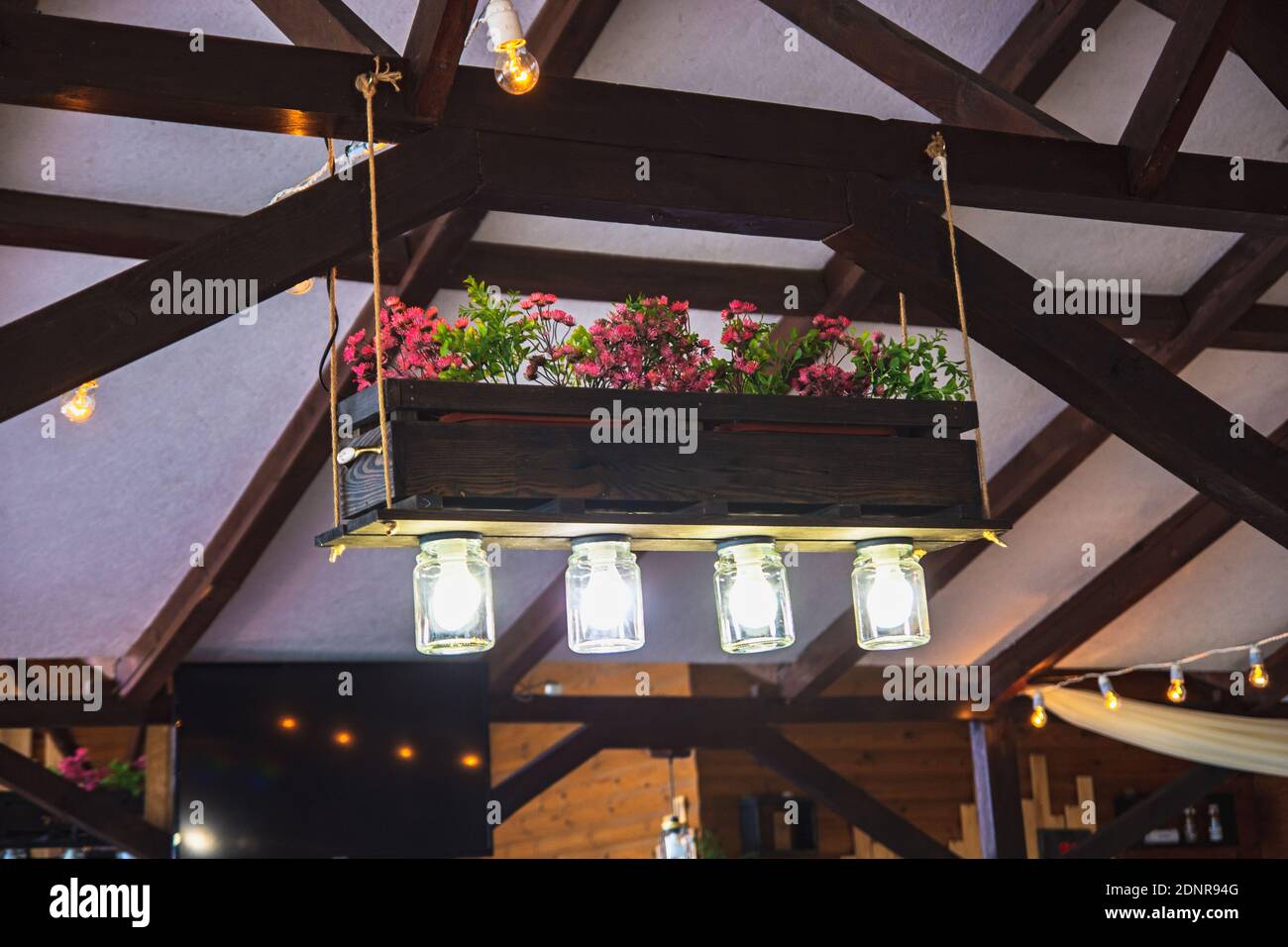 Original Kronleuchter aus Gläsern und einem Blumentopf mit Blumen Stockfoto