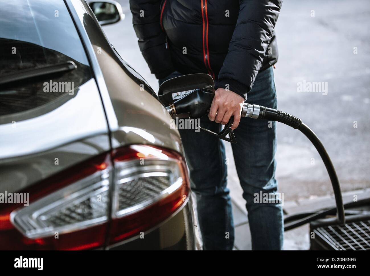 Mann betankt sein Auto in der Gas- oder Tankstelle mit Naphtha oder Öl-Kraftstoff, Betankung Prozess Stockfoto