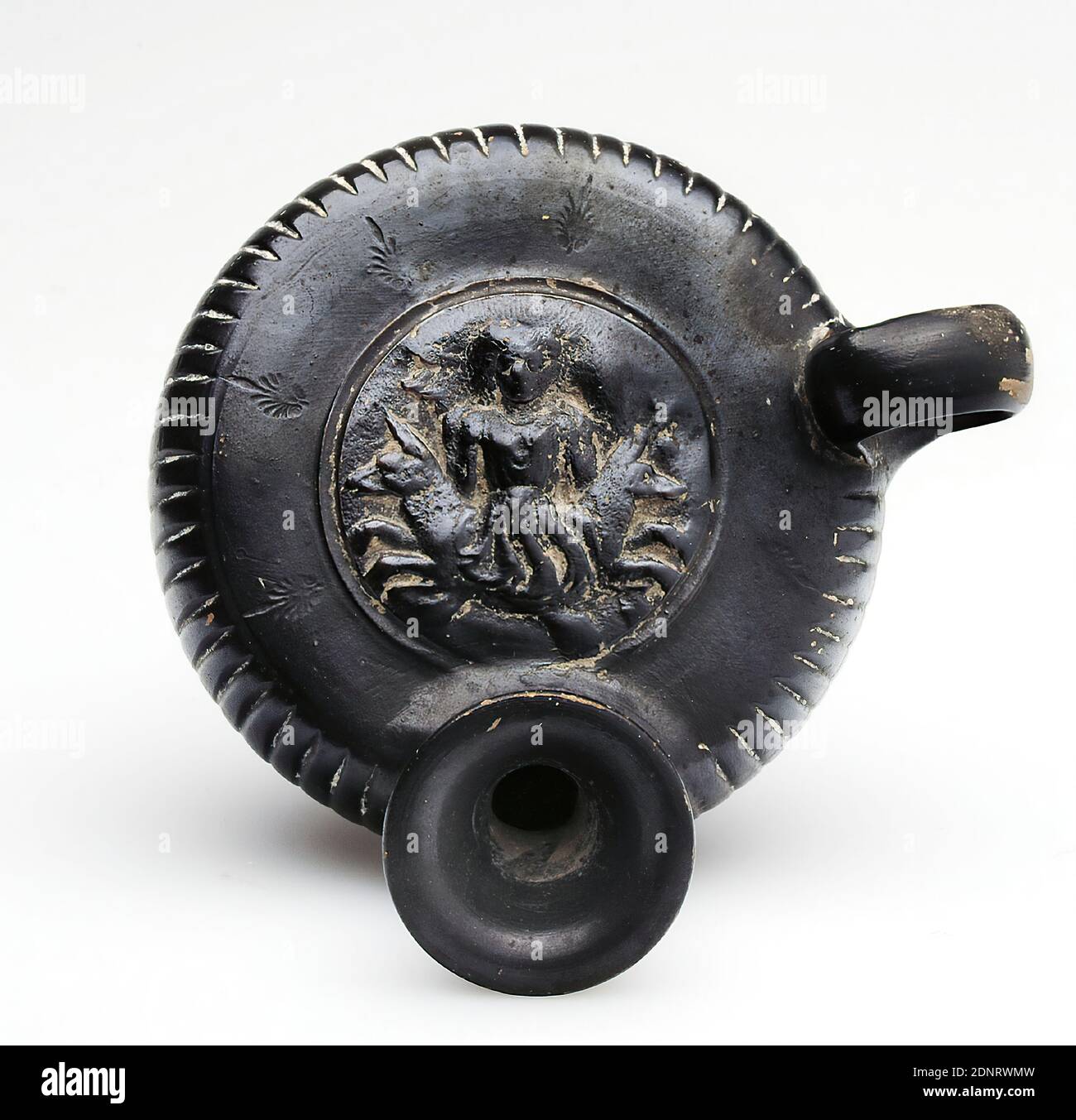 Guttus mit gestempeltem Palmettenring (Skylla), ehemals Johannes W. F. Sammlung Reimers (Hamburg), Ton, schnell gedreht, handmodelliert, Pressdekor, gestempelt, gebrannt (Keramik), Ton, Gesamt: Höhe: 8.3 cm; Durchmesser: 9.5 cm; Grunddurchmesser: 6 cm; Breite: 11.2 cm; Tiefe: 11.2 cm; Durchmesser: 4.7 cm (Medaillon); Höhe: 1 cm (gestempelte Palmette), Töpferei, Scylla (Seeungeheuer), Spätklassiker (griechische Antike), griechische Antike, der Guttus hat eine stockige Form, oben und unten abgeflacht, mit einem profilierten niedrigen Fuß, einem vertikalen Griff und einem abfallenden Auslauf. Der Körper des Gefäßes ist vertikal gerillt. Stockfoto