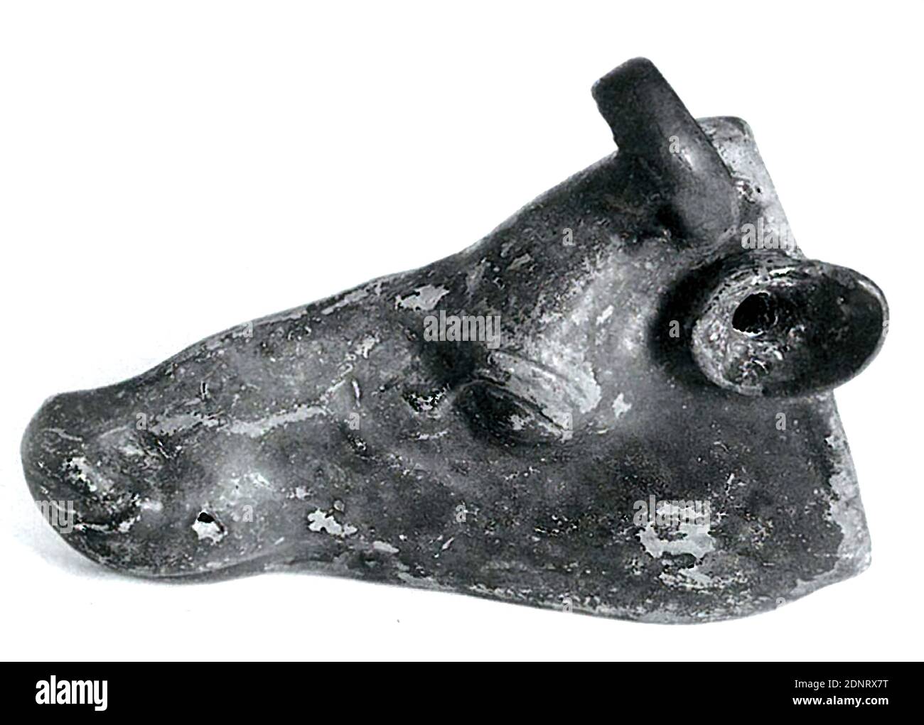 Rhythmon in Form eines halbierten Rinderkopfes, Ton, gesamt: Höhe: 4.5 cm; Breite: 12.2 cm; Tiefe: 10 cm, Keramik, Rinder, Rinder, Stier, Spätklassik (griechische Antike), frühhellenistisch, griechische Antike, das Gefäß hat die Form eines Stierkopfes, der in der Länge halbiert ist. Die Schnittfläche ist geschlossen und dient als Boden. Das Ohr ist auch der Auslauf. Anstelle der Hupe ist ein Ringgriff angebracht. Lebhaft und lebensecht modellierte Formen: Die Tränendrüse am Auge und die Venen am Nasenrücken sind anschaulich dargestellt. Stockfoto