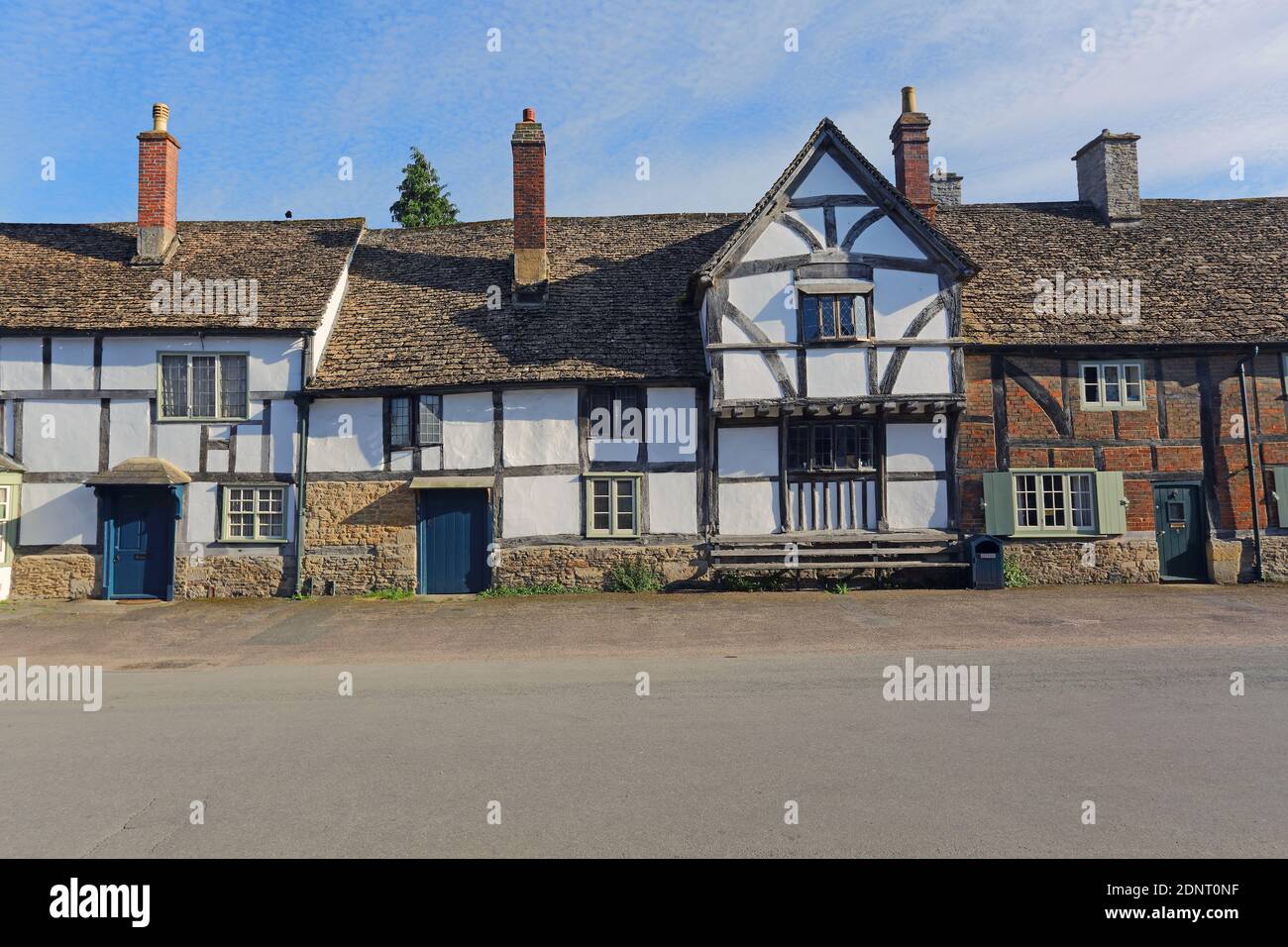 High Street, Lacock, Wiltshire mit einer Reihe von Häusern, die hauptsächlich aus dem späten Mittelalter stammen. Sie sind mit Holzrahmen mit Gipsplatten und Steinschieferdächern ausgestattet. Stockfoto