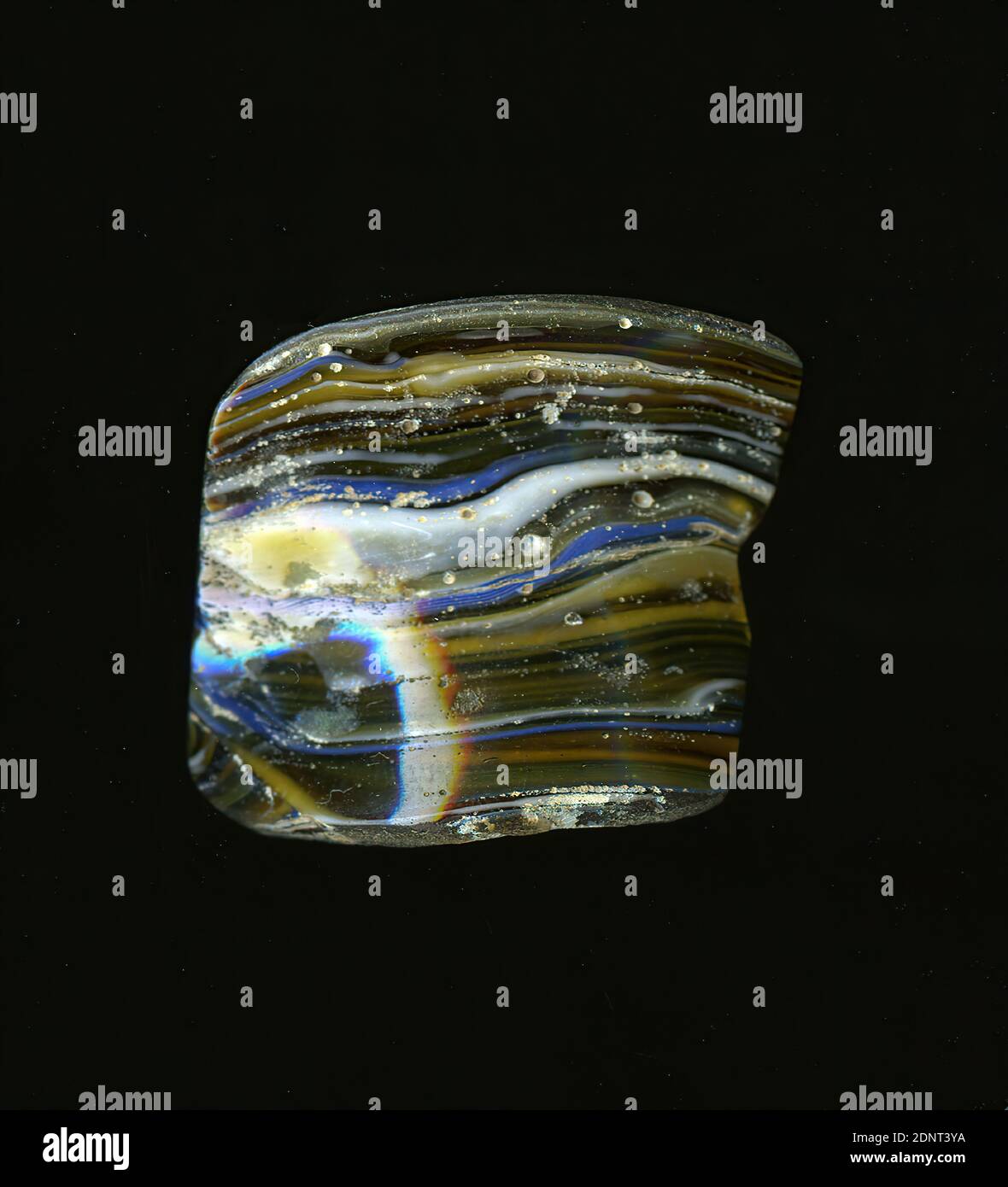 Fragment eines Gefäßes, Glas, gepresst, geschnitten, Gesamt: Höhe: 3.30 cm; Breite: 3.00 cm, Behälter, Lagerung, Küchenarbeit, frühkaiserliche Zeit, EINE leichte Krümmung des Glassfragments ermöglicht die Zuordnung zu einem Gefäß, möglicherweise einer Schüssel. Unregelmäßig verlaufen feine weiße und blaue Streifen durch das helle bis dunkelbraune Glas. Für die Herstellung wurden verschiedenfarbige Gläser zu Rohren und Stäben geformt. Diese wurden zusammengedrückt und erhitzt, was zu einer langen Stange führte. Das nun in Scheiben geschnittene Glas hatte unterschiedliche Muster. Stockfoto