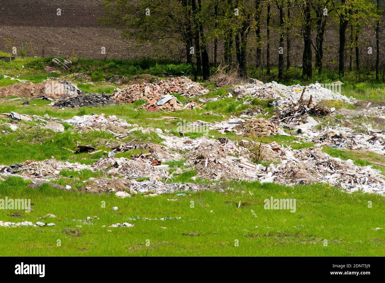 Nicht autorisierter Speicherauszug. Auf dem grünen Gras liegen Haufen Bauschutt Stockfoto