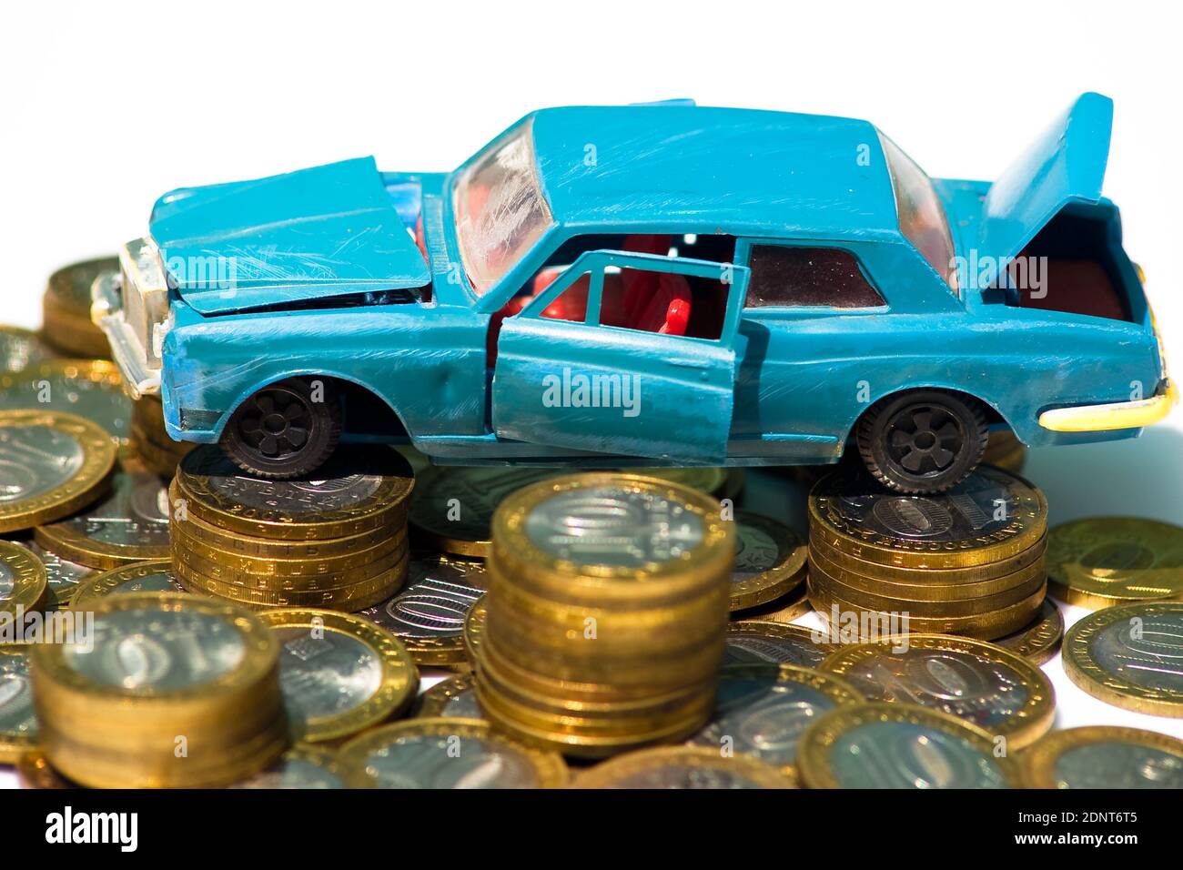 Die Kosten für die Wartung eines alten Autos. Ein Modell eines alten Autos steht auf Münzen. Das Konzept der teuren Wartung eines alten Autos oder dessen Entsorgung Stockfoto