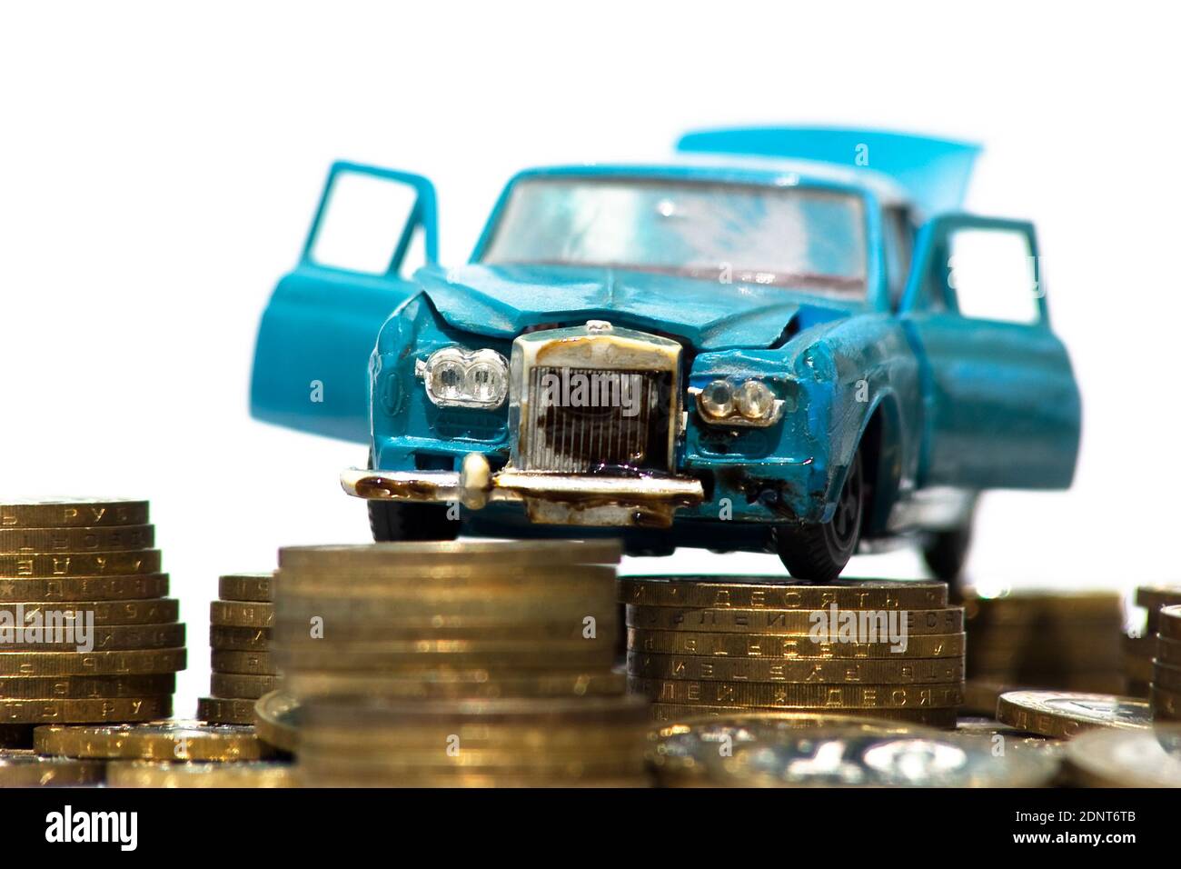 Die Kosten für die Wartung eines alten Autos. Ein Modell eines alten Autos steht auf Münzen. Das Konzept der teuren Wartung eines alten Autos oder dessen Entsorgung Stockfoto