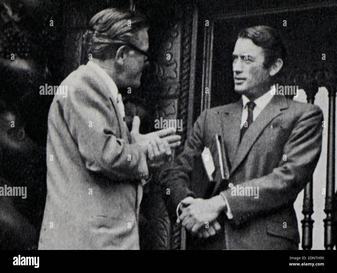 Foto von Gregory Peck (1916-2003) im Gespräch mit Earl St. John (1892-1968). Stockfoto