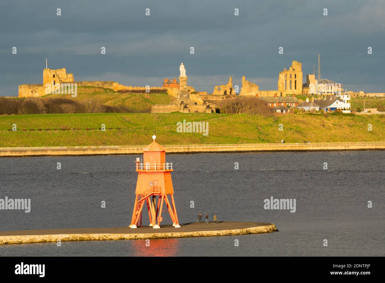 Die Herde Groyne Leuchtturm und Tynemouth Burg und Priorat Gebäude von South Shields, Nordostengland, Großbritannien gesehen Stockfoto