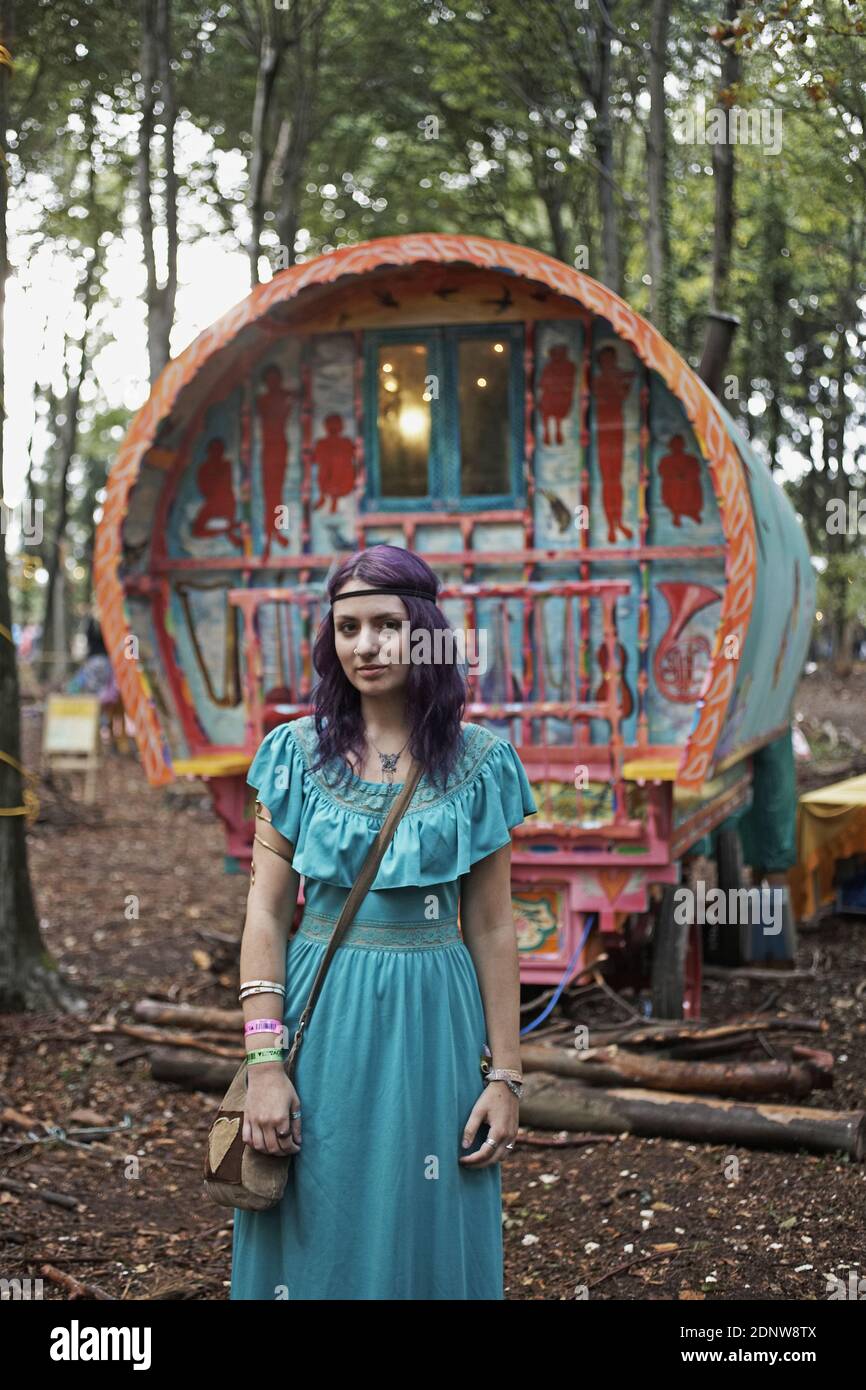 Junge unkonventionelle Hippie-Mädchen posiert vor Zigeunerwagen im Wald. Stockfoto