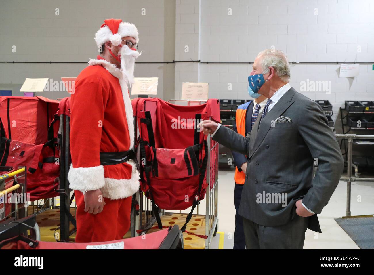 Der britische Prinz Charles spricht mit dem Postarbeiter Tim Lafford, der ein Weihnachtskostüm trägt, bei einem Besuch im Zustellbüro von Royal Mail in Cirencester, Großbritannien, 18. Dezember 2020. Geoff Caddick/Pool via REUTERS Stockfoto