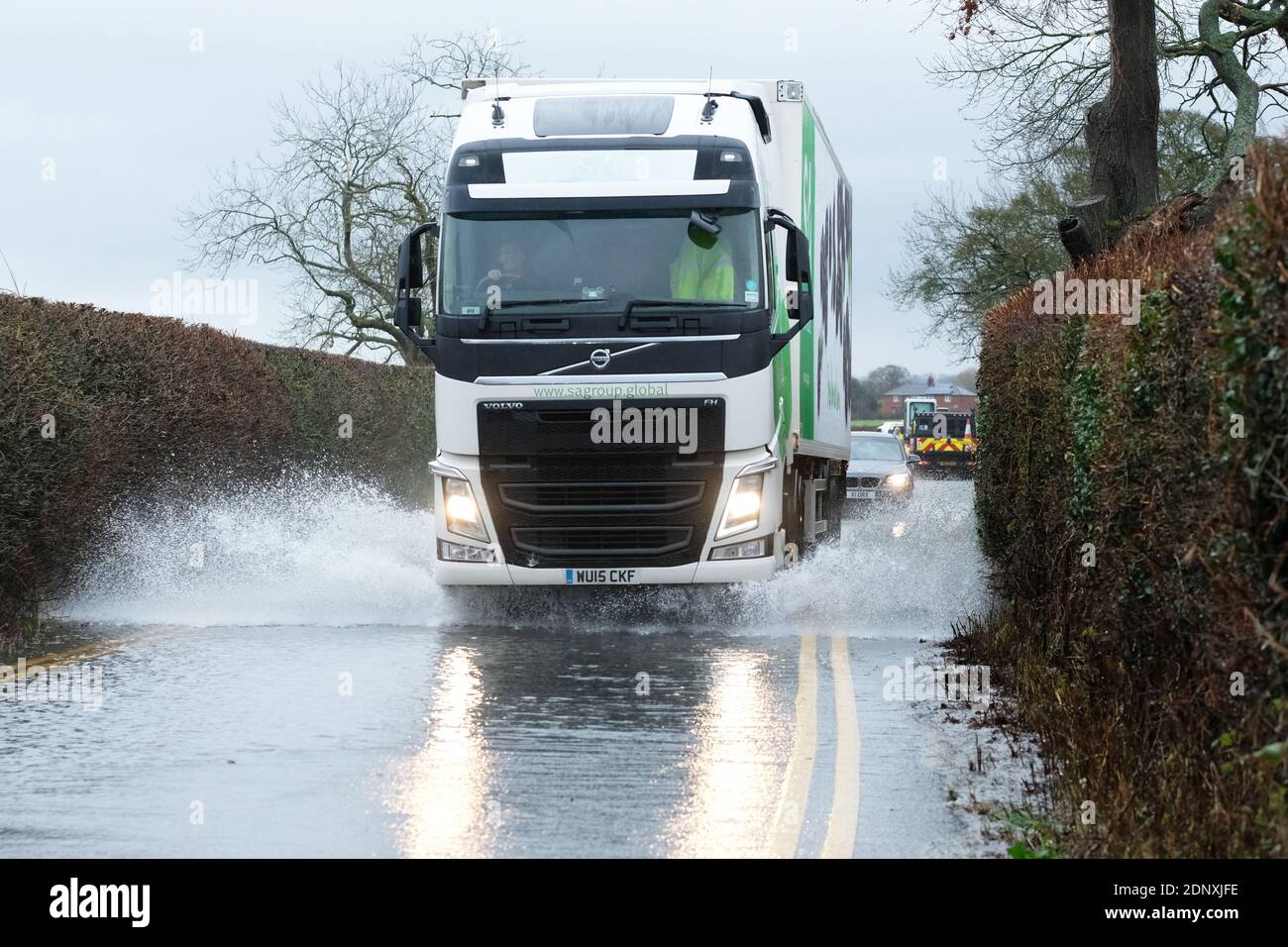 Moreton-on-Lugg, Herefordshire, Großbritannien - Freitag, 18. Dezember 2020 - Fahrzeuge fahren durch Oberflächenwasser-Überschwemmungen, die vom nahe gelegenen Fluss Lugg nach einem weiteren Tag heftiger Regenfälle über Herefordshire und Mid Wales überschwemmt wurden. In Herefordshire bleiben sowohl der Fluss Wye als auch der Fluss Lugg auf Hochwasseralarm und werden voraussichtlich steigen. Foto Steven May / Alamy Live News Stockfoto