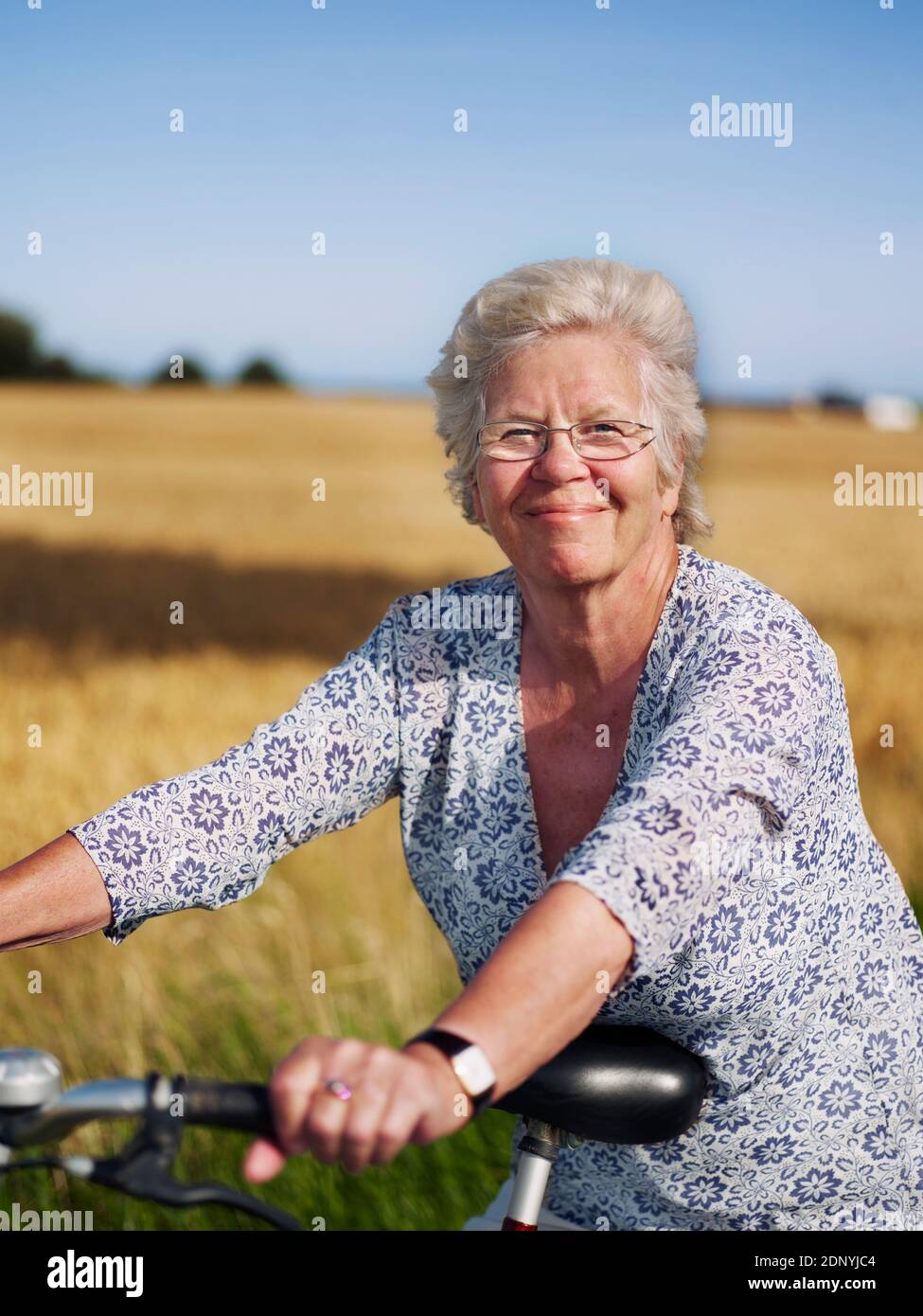 Lächelnde Frau mit Fahrrad Stockfoto