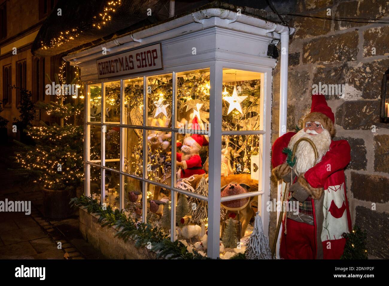 Großbritannien, Gloucestershire, Broadway, High Street, Fenster des Weihnachtsshops am Abend des späten Abendshops im Dezember Stockfoto