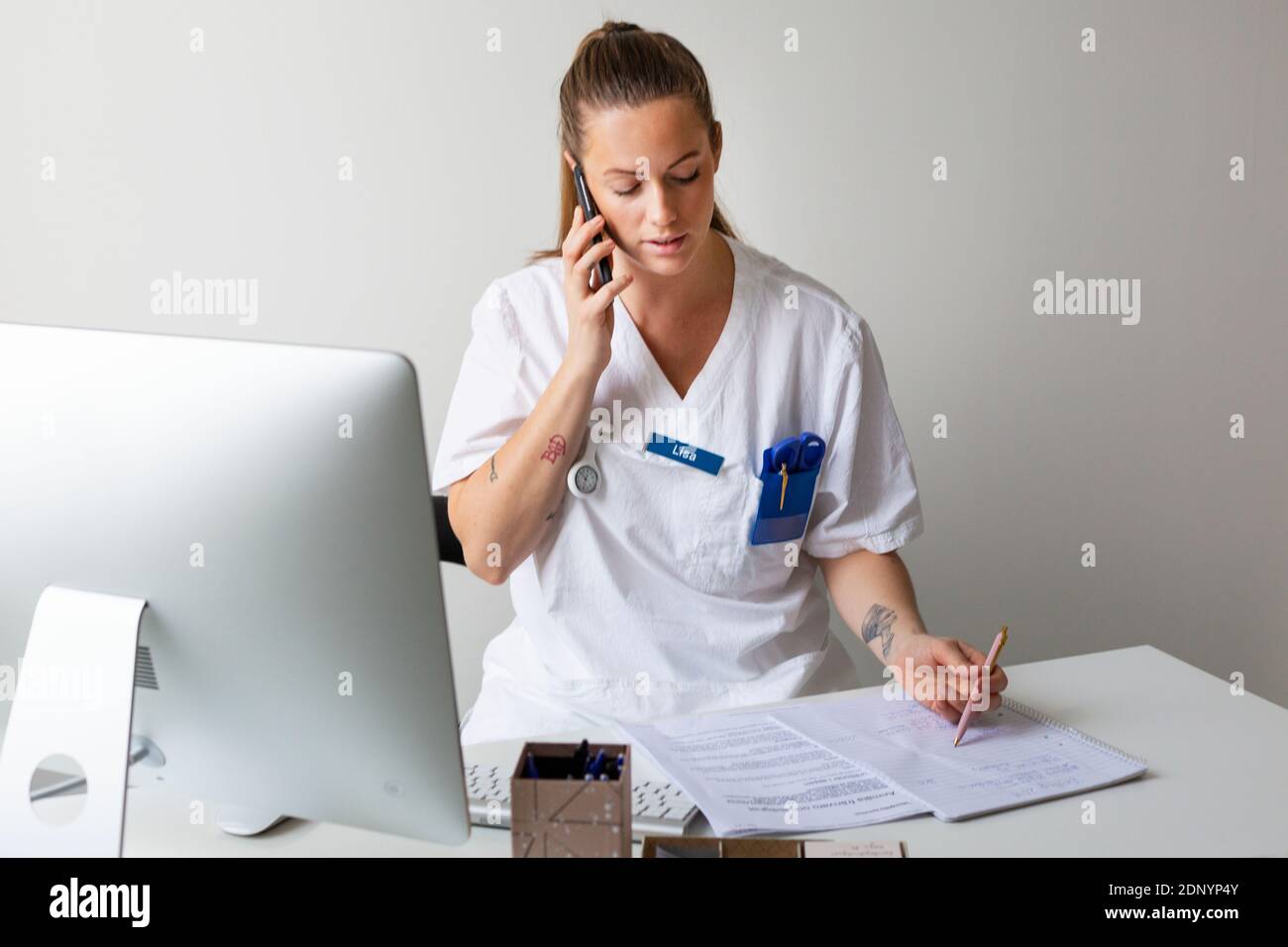 Krankenschwester im Büro, die per Handy spricht Stockfoto