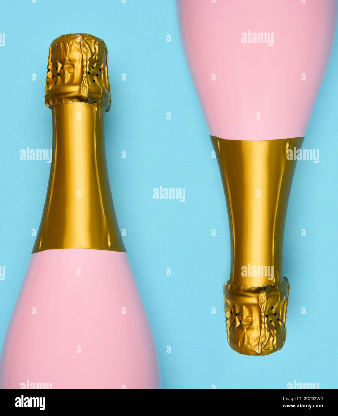 Zwei Pink Champagne Flaschen auf blauem blauem blauem Hintergrund. Horizontale Aufnahme mit großem Winkel. Stockfoto