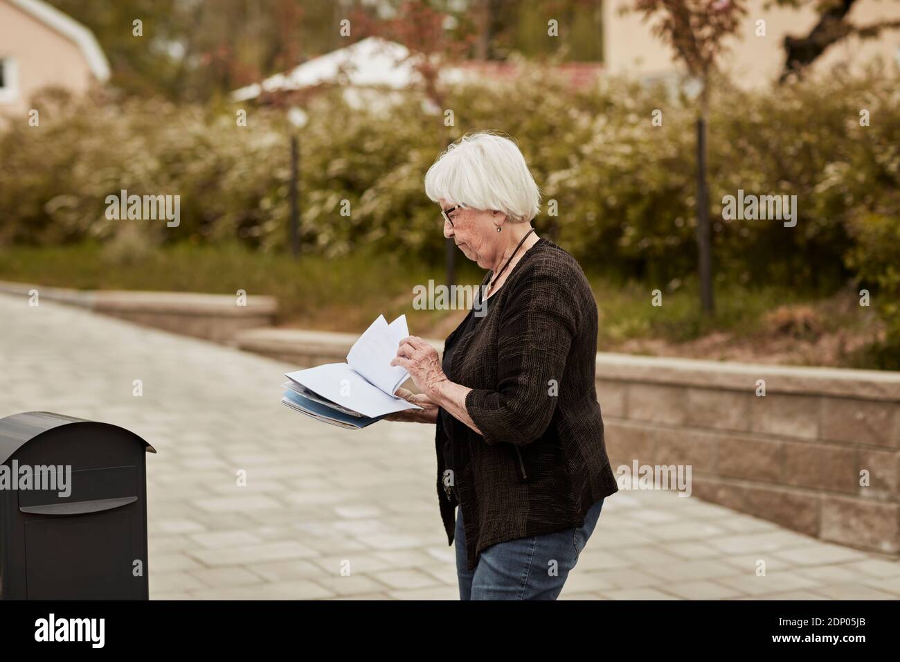 Ältere Frau in der Nähe des Postfachs Stockfoto