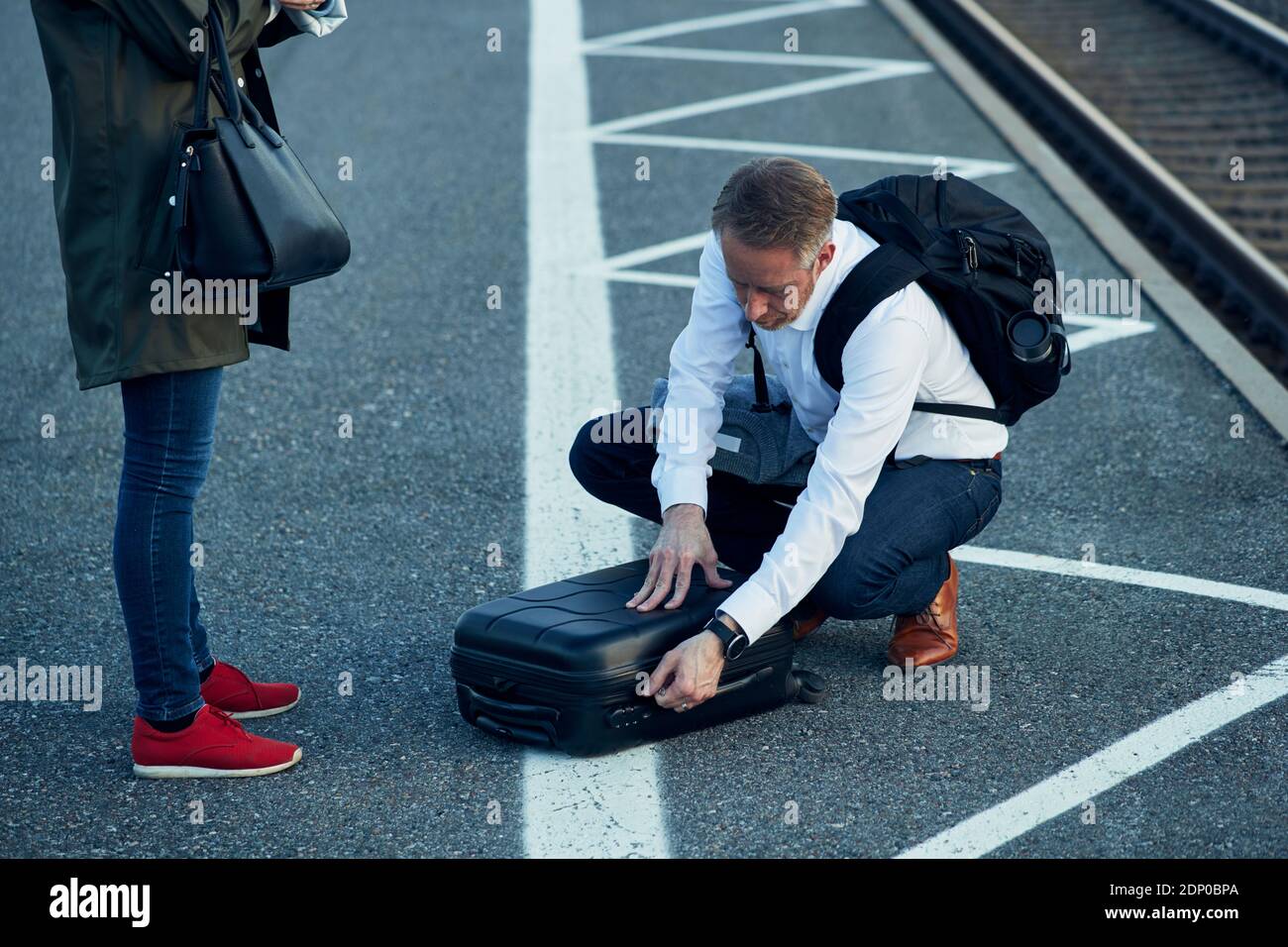 Mann am Bahnhof, der den Koffer öffnete Stockfoto