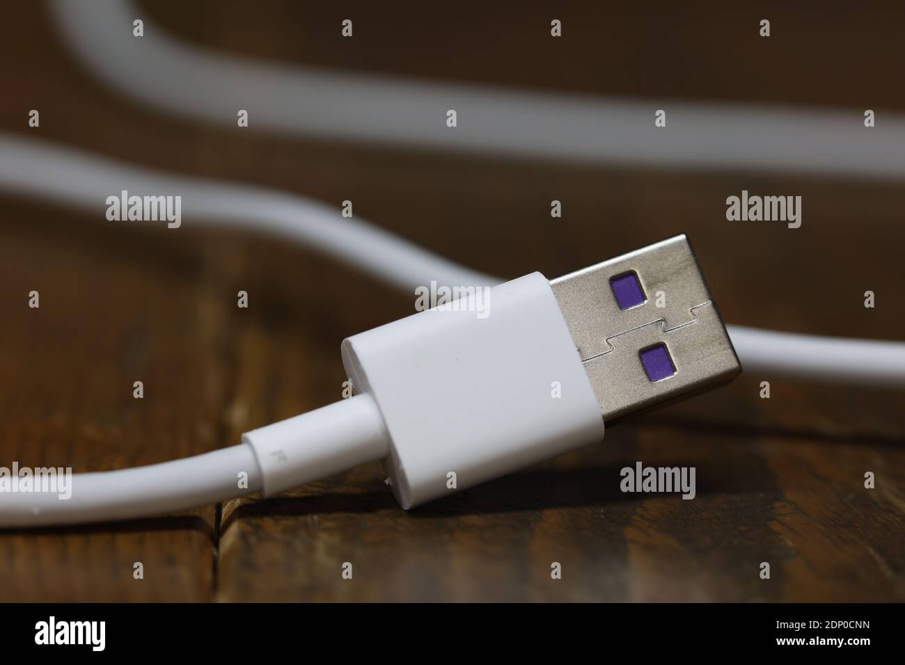 USB-Kabel zum Aufladen des Telefons auf einem unscharfen Hintergrund. Stockfoto
