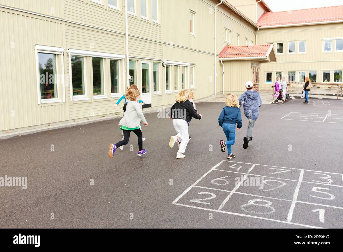 Kinder laufen auf dem Schulhof Stockfoto