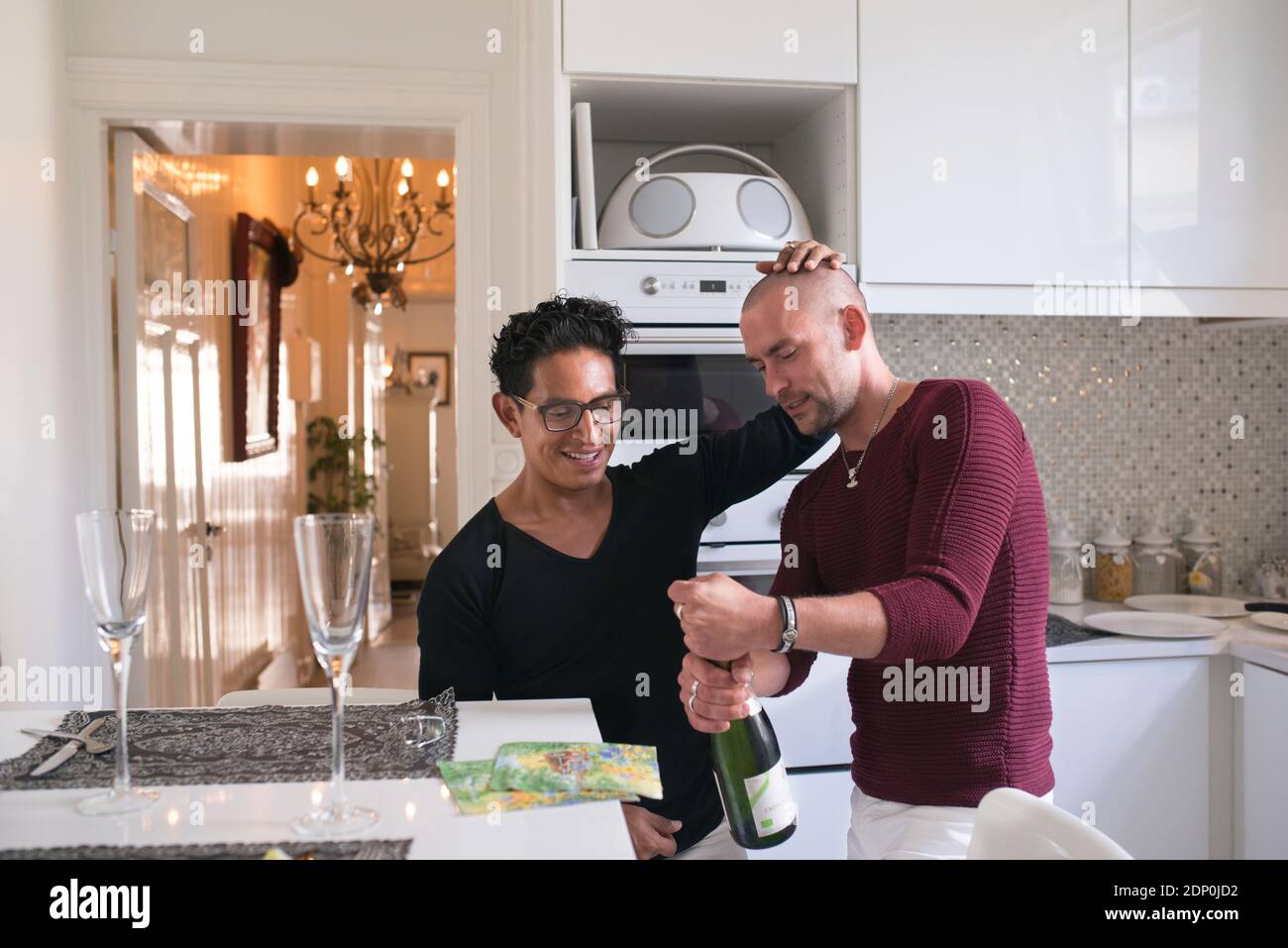 Männliches Paar eröffnet Champagner Stockfoto