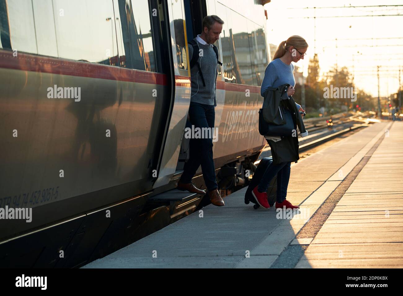 Ein Paar verlässt den Zug am Bahnhof Stockfoto