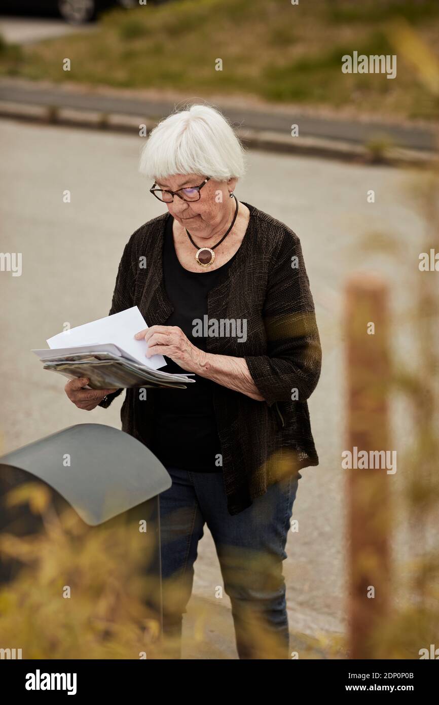 Ältere Frau in der Nähe des Postfachs Stockfoto