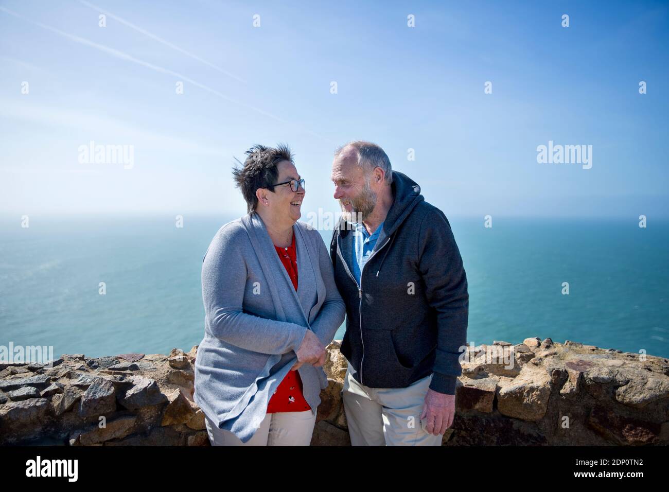 Lächelndes Paar steht zusammen, Meer auf dem Hintergrund Stockfoto